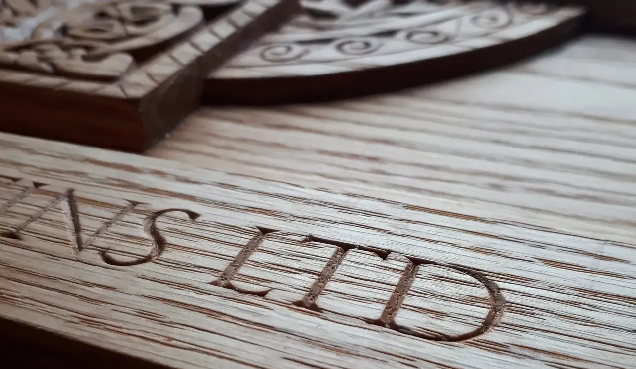 An oak sign, focusing on the hand carved letters LTD