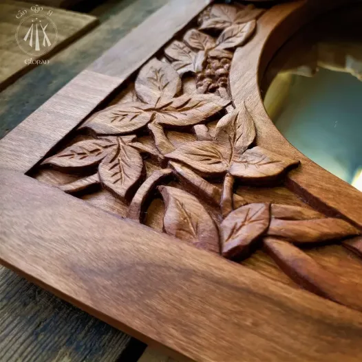 A cherry wood mirror, with a border of hand carved leaves and decorative fruits